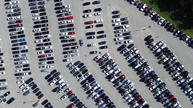 Cars driving around looking for parking spot at full large outdoor lot of electric, gas vehicles in Arlington, Texas, parallel pattern, pavement marking number, parking management in metropolitan. USA