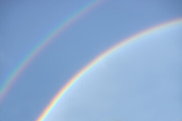 Double rainbow in a clear blue sky on a sunny day. Natural rainbow.