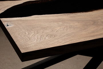 Expensive vintage furniture. The table is covered with epoxy resin and varnished. Luxury quality wood processing. Wooden table on a dark background. Black river made of epoxy resin.