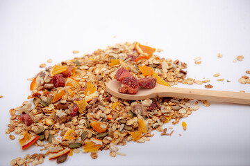 Healthy breakfast.Healthy granola.Healthy lifestyle.Healthy fruits.Kitchen in background.White background.Wooden spoon inside it