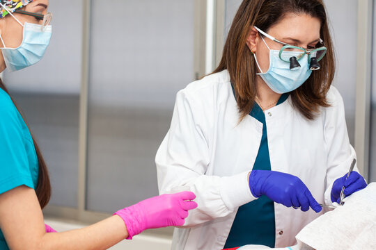 Skin lesion removal procedure. Dermatologist carrying out a removal of benign skin lesion on the face of a young male patient.