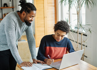 father child home family homework son  teenage parent education laptop teen boy teaching childhood...