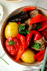Cutlets with vegetables in a cauldron in Azerbaijani style.