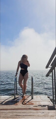 blond woman after cold dip in the sea after sauna in helsinki, finland