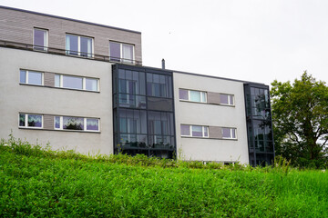 Grey building with many windows. Green grass hill in the front. Summer daytime. Tallinn, Estonia, Europe. July 2024