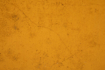 A close up of a weathered yellow wall