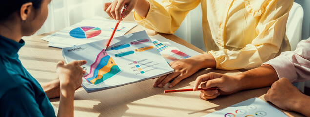 Obraz premium Startup company employee working together, analyzing BI dashboard paper on financial data report and planning strategic marketing for business success in panorama banner. Synergic