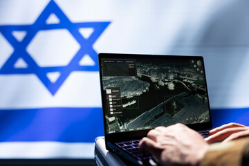 Israeli IDF army specialist using target acquisition tech on laptop to detect enemy location, close...