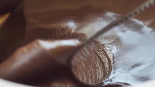 Super close up of a table knife taking chocolate nut butter to make a sandwich. Have breakfast with nut and cocoa spread. Brown hazelnut spread with vegetable fat added