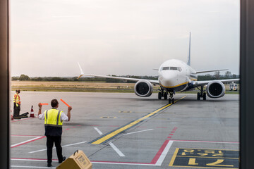 Airport Worker Directing Airplane for Parking After Landing.