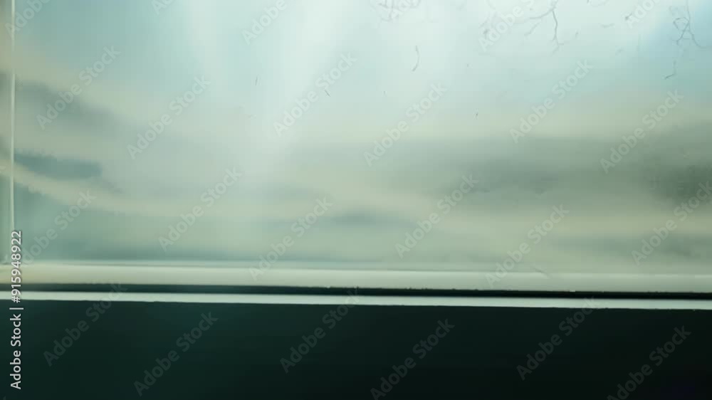 Poster The camera slowly pans across a window revealing intricate patterns of dust that have accumulated in the corners and edges.
