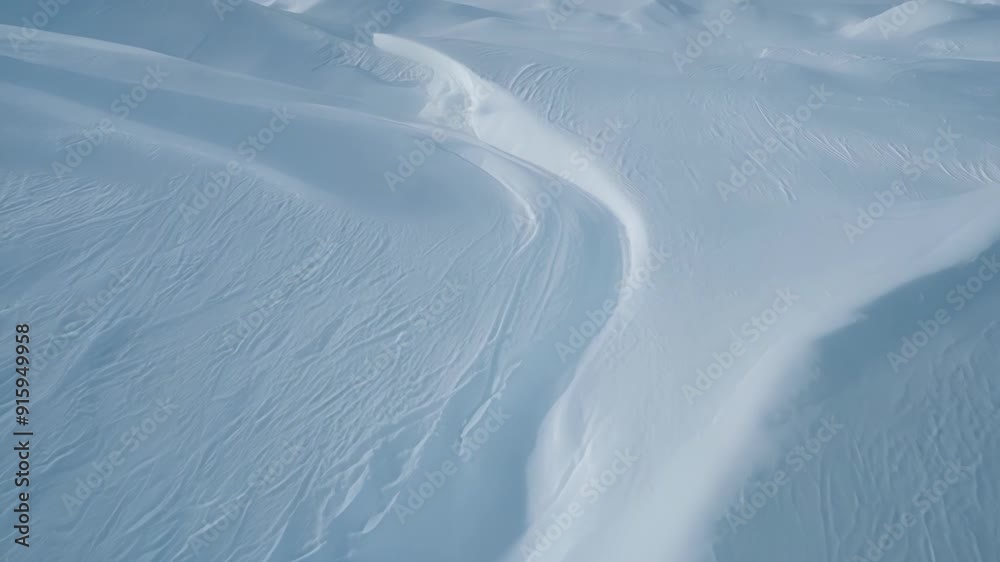 Poster From a low angle view the camera captures the striking contrast between the smooth fluid lines and sharp jagged edges of the snow drift patterns in this immersive closeup shot.
