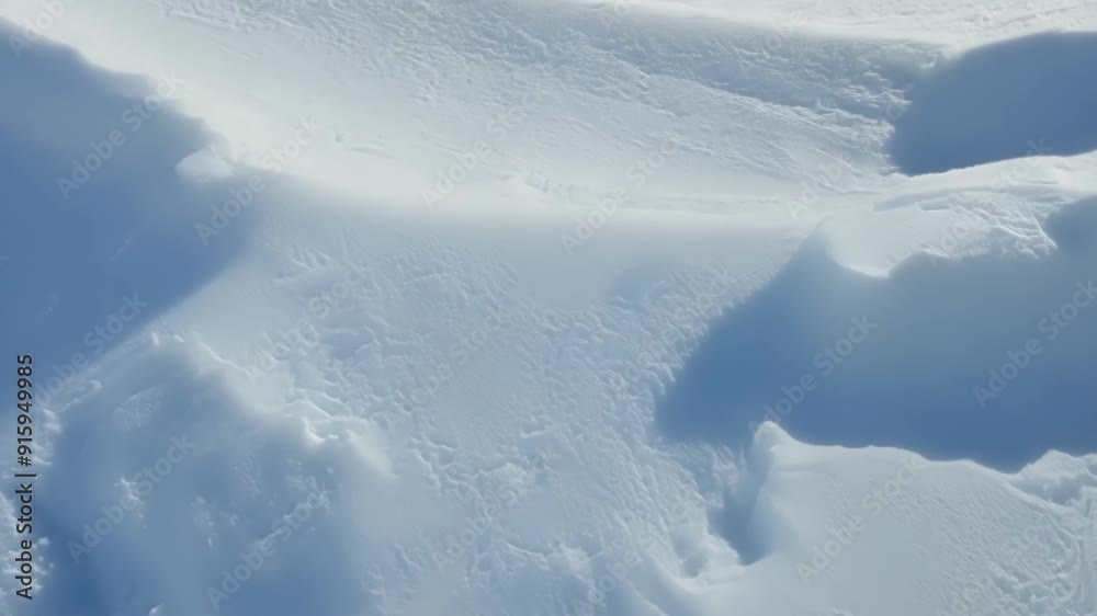 Fototapete The changing light and shadows play across the curves and peaks of the snow drifts in this mesmerizing closeup highlighting their intricate and everchanging patterns.