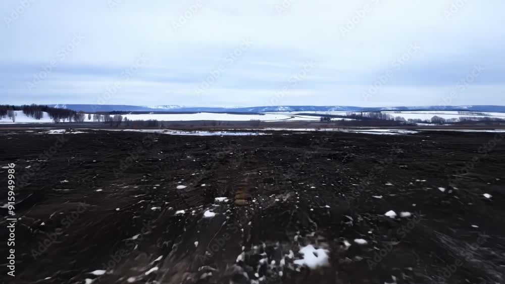 Poster a timelapse of a snowy landscape transforming into a wet muddy terrain as the snow melts away.