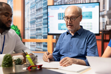 Senior man signing the contract for a retirement plan package to ensure their future income,...