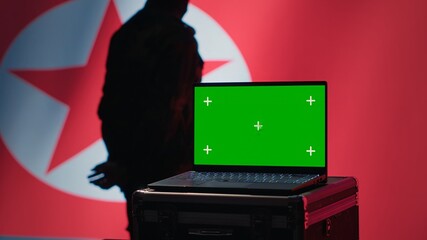 North Korea secret police agent uses mass propaganda tools on green screen laptop to influence...