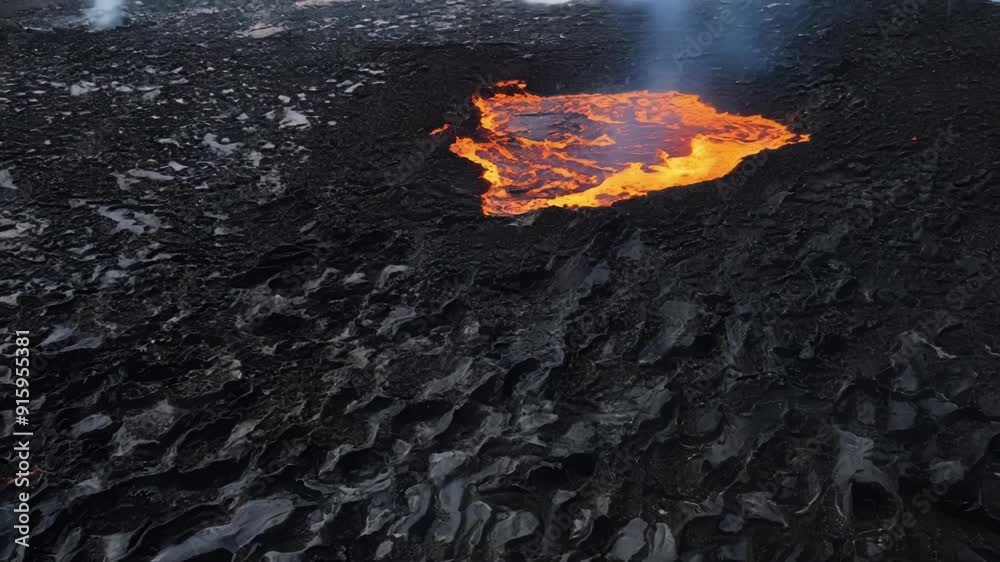 Poster Sharp jagged lines of black and grey lava crisscross over a field of hardened lava creating a stark contrast of colors and textures as the molten lava continues to flow and bubble.