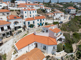 A picturesque village nestled on a cliffside boasting charming whitewashed houses with terracotta roofs