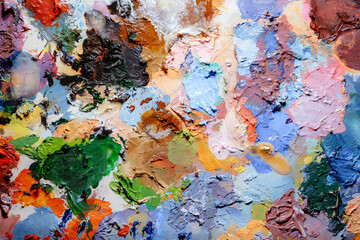 Colorful abstract texture. Smears of oil paint and a palette knife on an art palette. The concept of the modern school of art. Fragment of creative work. Colors of the year 2024