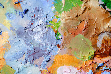Colorful abstract texture. Smears of oil paint and a palette knife on an art palette. The concept of the modern school of art. Fragment of creative work. Colors of the year 2024