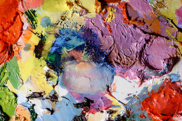 Colorful abstract texture. Smears of oil paint and a palette knife on an art palette. The concept of the modern school of art. Fragment of creative work. Colors of the year 2024