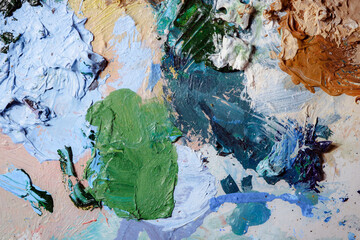 Colorful abstract texture. Smears of oil paint and a palette knife on an art palette. The concept of the modern school of art. Fragment of creative work. Colors of the year 2024