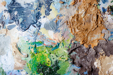 Colorful abstract texture. Smears of oil paint and a palette knife on an art palette. The concept of the modern school of art. Fragment of creative work. Colors of the year 2024