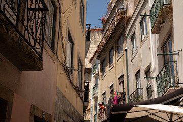 A narrow street in Lisbon Portugal with colorful laundry hanging outside windows