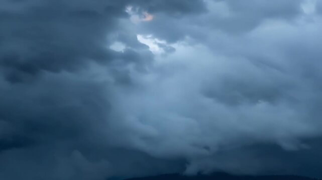 A closeup shot of dark grey storm clouds rolling and cascading over one another.