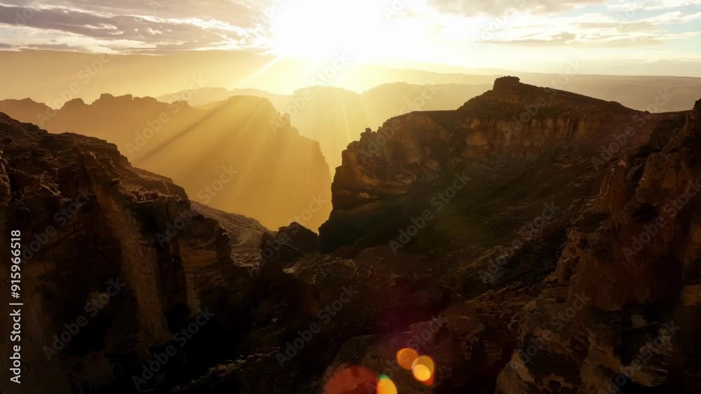 Poster The suns rays continue to stretch across the sky casting dramatic shadows on the jagged cliffs of a rocky landscape.