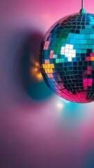 Obraz premium A disco ball is hanging from a wall, with a colorful light shining on it