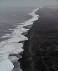 Ocean waves crashing on black sand beach in iceland