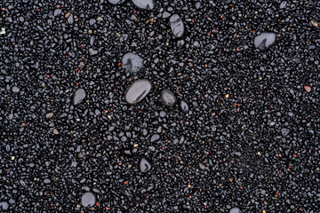 Wet black volcanic sand forming abstract background texture