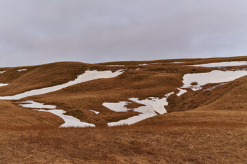 Patches of snow are slowly melting on the hillsides in early spring