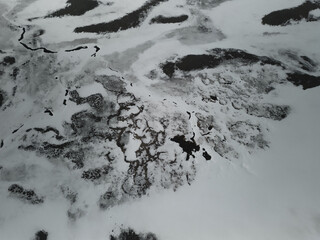 Frozen lake melting during spring thaw with snow and ice