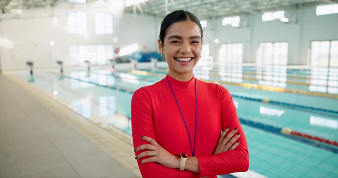 Woman, swimming coach and laughing in indoor aquatic center, arms crossed and confident for lesson. Female person, happy and instructor as teacher with smile, whistle and ready for session by pool