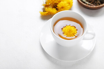 Cup of healthy dandelion tea on white background