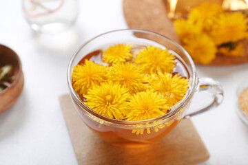 Glass cup of healthy dandelion tea on white background