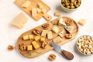 Wooden boards with pieces of tasty cheese on light background