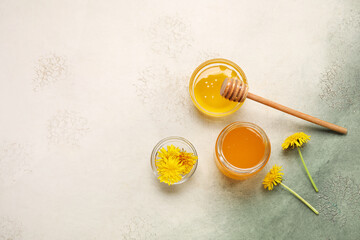 Jar and bowls with dandelion honey on white background