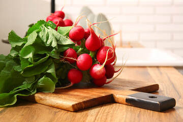 Wooden board with fresh radish on table in kitchen