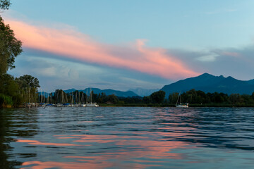 Beautiful evening at the shores of Chiemseestrand in Bavaria. The calm lake, colorful sky, and...