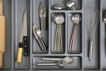 Open kitchen drawer with different silver cutlery