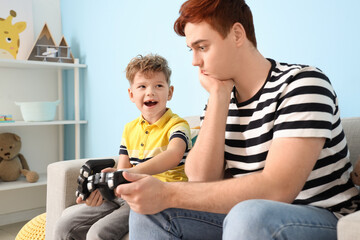 Little boy with his father playing video game at home