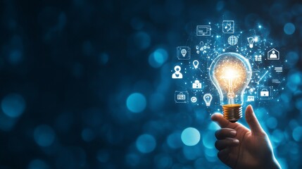 Hand holding light bulb with digital icons and network connection on blue background, representing innovation in technology for business or education. High quality, professional photography