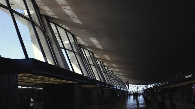 People at Dulles Airport: Passengers walk through the terminal under a clear blue sky. The daytime activity reflects the vibrant energy typical of a major airport