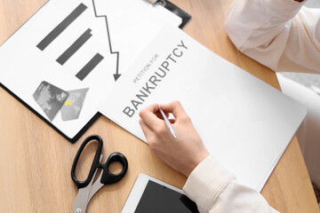 Young woman filing petition for bankruptcy at home, closeup