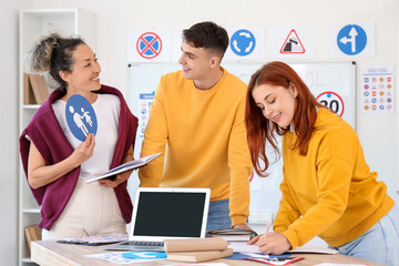 Obraz premium Female instructor with road sign giving lesson to people at driving school
