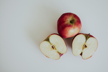 red full and cut in half apples on white background