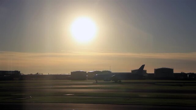 Evening Activity at Amsterdam Schiphol Airport, Planes Moving on Runway at Sunset